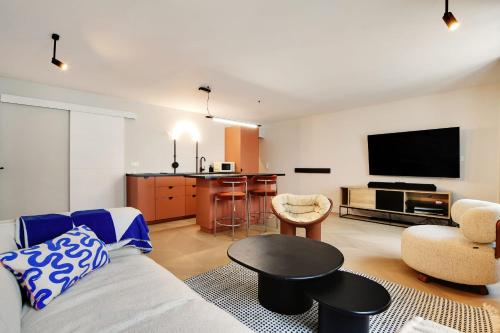 uma sala de estar com um sofá e uma televisão de ecrã plano em Luxury Flat Four Peoples em Clichy