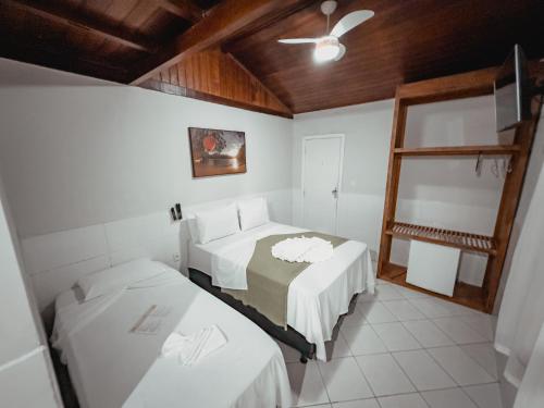 a room with two beds and a mirror in it at Pousada Porto Girassol in Abraão