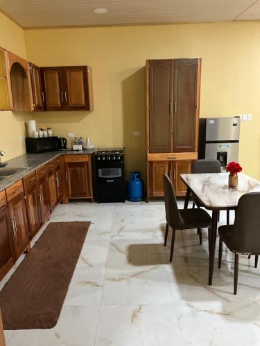 a kitchen with wooden cabinets and a table with chairs at Fully Furnished 3 Bedroom - Shaveh Apartment Rentals 