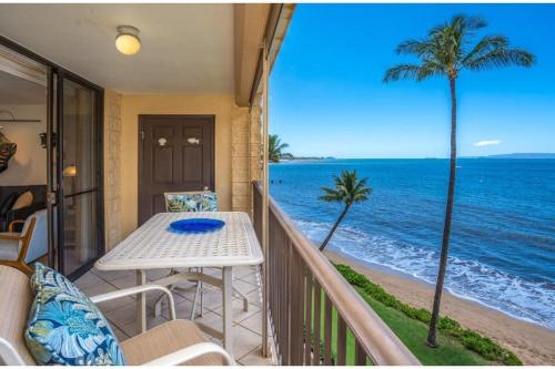 a balcony with a table and a view of the ocean at KIHEI BEACH #504 condo in Kihei