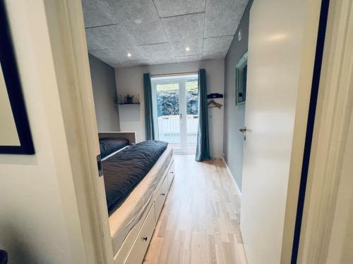 um quarto com uma cama e uma grande janela em Rosie’s Neyst em Vestnanhavn