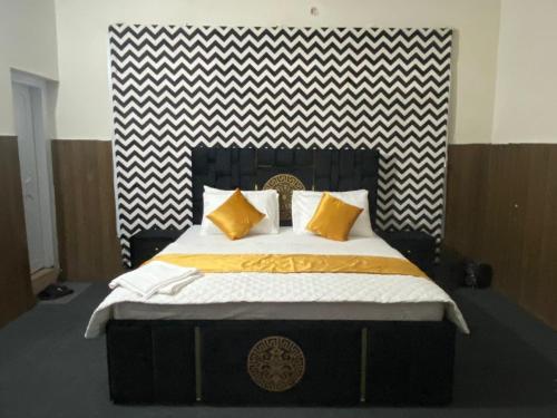 um quarto com uma cama grande e almofadas amarelas em The Nook em Muzaffarabad