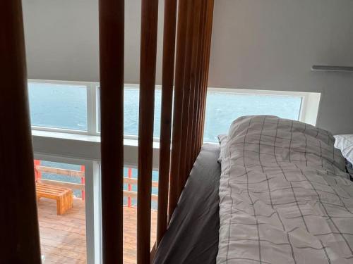 um quarto com uma cama e vista para o oceano em Rosie’s Neyst em Vestnanhavn
