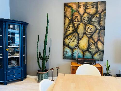 a dining room with a table and a painting on the wall at Rosie’s Neyst in Vestmanna