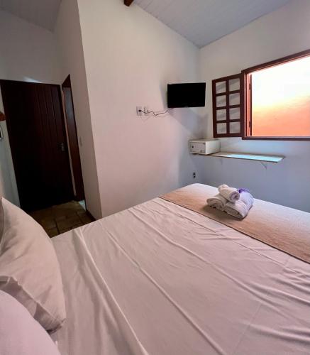 a bedroom with a bed with towels on it at Pousada Alforria in Búzios