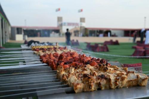 a row of slices of pizza on a grill at Campsite for Stays, Event Parties, holidays with Foods and Entertainments in Dubai