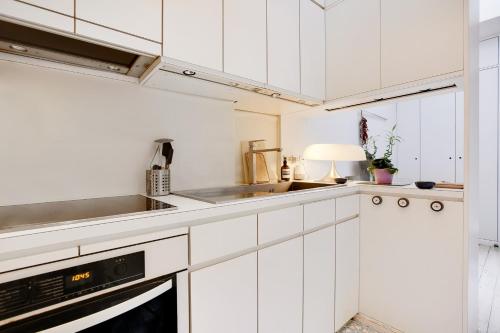 une cuisine blanche avec des armoires blanches et un évier dans l'établissement PLACE D'ITALIE Luxury Flat, à Paris