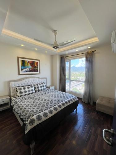 a bedroom with a bed and a large window at Elysium Luxury One Bedroom Apartment Opposite Centaurus Mall Islamabad in Islamabad
