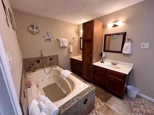 a bathroom with a large tub and a sink at A huge Sprawling House on a large lot -15 minutes to St Louis in Belleville