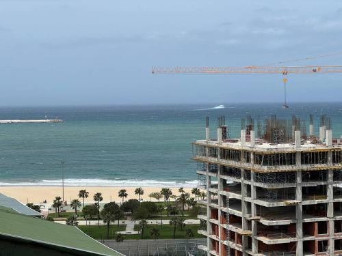 a building under construction next to the beach with a crane at Luxury Appartement Guesshouse in Tangier