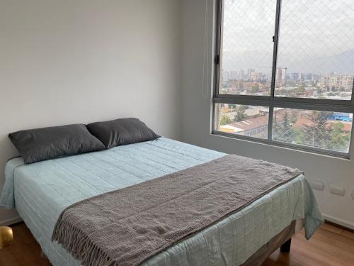 a bedroom with a bed and a large window at Apartamento completo Santiago cerca Movistar Arenas in Santiago