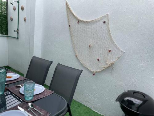 a table with chairs and a net on a wall at Increíble Casa con alberca y club de playa in Barra Vieja