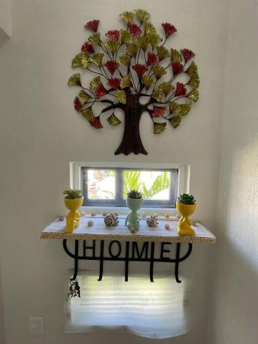 a table with a tree decoration on a wall at Increíble Casa con alberca y club de playa in Barra Vieja