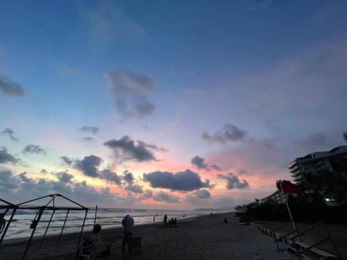 a group of people on the beach at sunset at Increíble Casa con alberca y club de playa in Barra Vieja