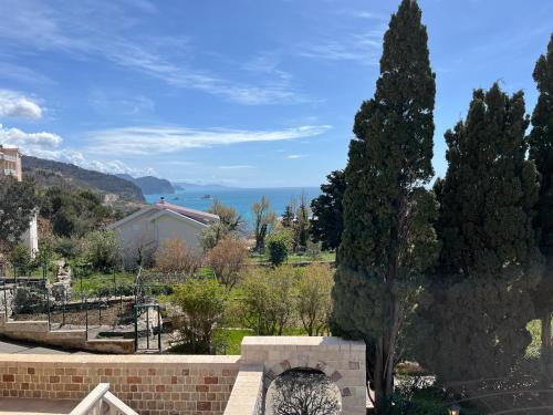 a garden with a brick wall and a tree at Vila Natalia in Petrovac na Moru