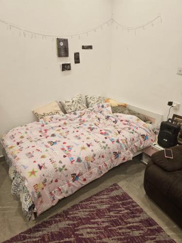 1 dormitorio con cama con edredón en New Naseem block 3, en Jahra
