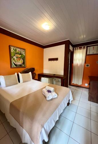 a bedroom with a large bed with towels on it at Pousada Alforria in Búzios