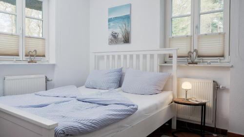 a white bed with blue sheets and pillows in a bedroom at Achtern Diek 12b - Wohnung 1 in Müggenburg
