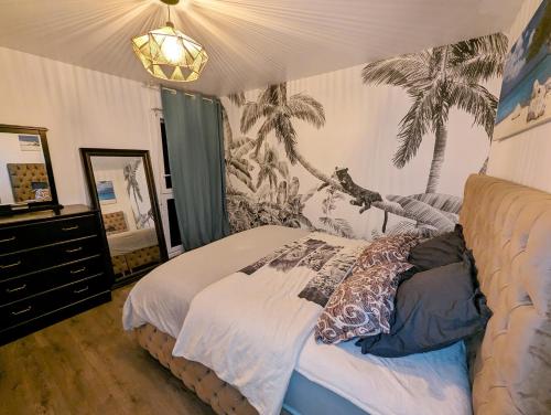 um quarto com uma cama com um mural de palmeira em Comfort Room I Renewed Duplex em Pantin