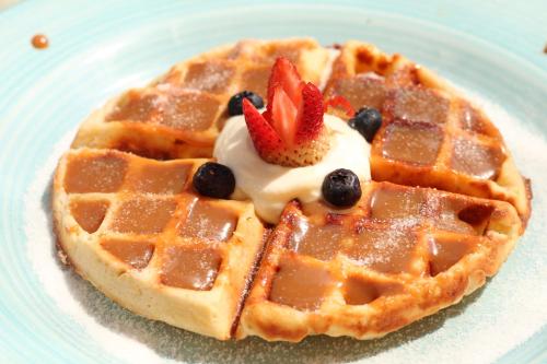 a waffle with strawberries and blueberries on a plate at Cocli Hotel Boutique Salento in Salento