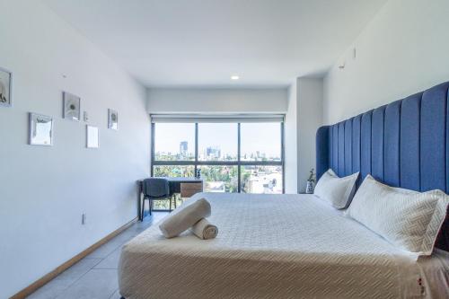 ein Schlafzimmer mit einem großen Bett und einem großen Fenster in der Unterkunft Chapultepec Condo best wifi in Guadalajara