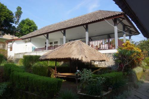 un gran edificio blanco con techo de paja en Horizon Senaru Villa, en Senaru
