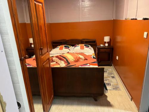Dormitorio pequeño con cama y puerta abierta en residence caramboles en Fort-de-France