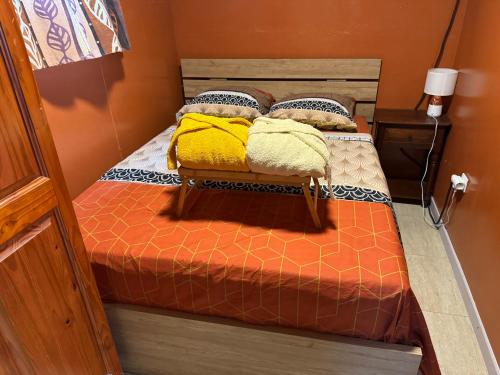 a bedroom with a bed with yellow pillows on it at residence caramboles in Fort-de-France