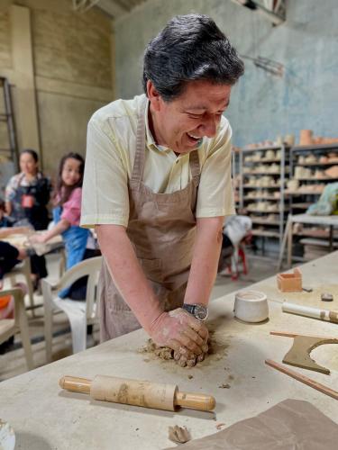 a man in apron making pottery on a table at VoyAca Hotel - Alfareria in Villa de Leyva