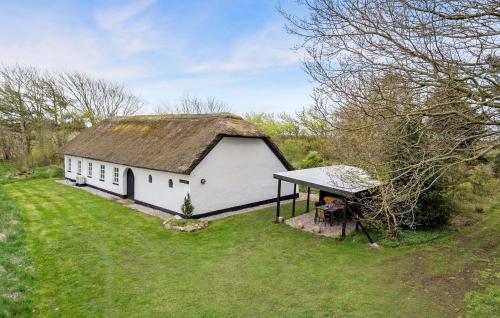 a white barn with a roof on a grass field at Amazing Home In Ulfborg With Kitchen in Ulfborg