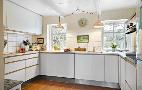 a white kitchen with white cabinets and windows at Amazing Home In Ulfborg With Kitchen in Ulfborg