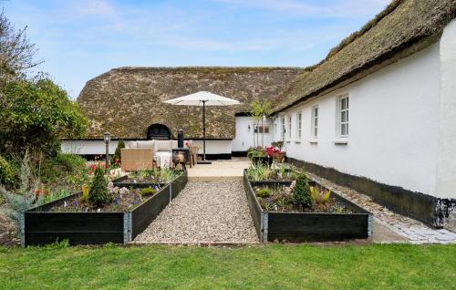 a house with three raised garden beds in the yard at Amazing Home In Ulfborg With Kitchen in Ulfborg