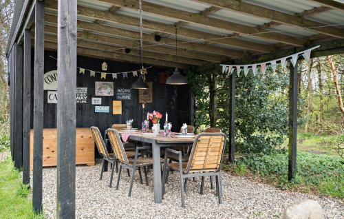 a table and chairs sitting under a pergola at Amazing Home In Ulfborg With Kitchen in Ulfborg