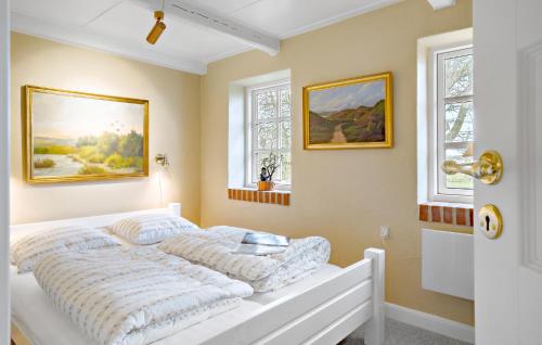 a white bed in a room with two windows at Amazing Home In Ulfborg With Kitchen in Ulfborg