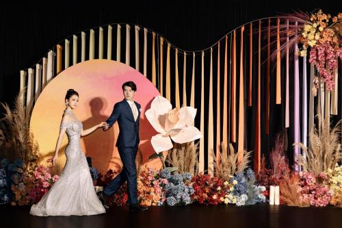 a bride and groom are standing in front of a backdrop at Crowne Plaza Guangzhou Huadu by IHG - Free Shuttle bus between hotel to Exhibition Center During Canton Fair in Guangzhou