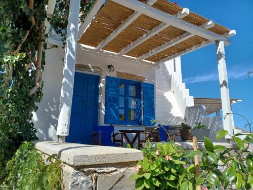 a white house with blue doors and a patio at Vicky's Studios in Órmos Aiyialís