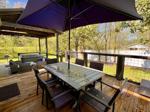 a table with chairs and an umbrella on a deck at Catons Chapel cabin in Sevierville