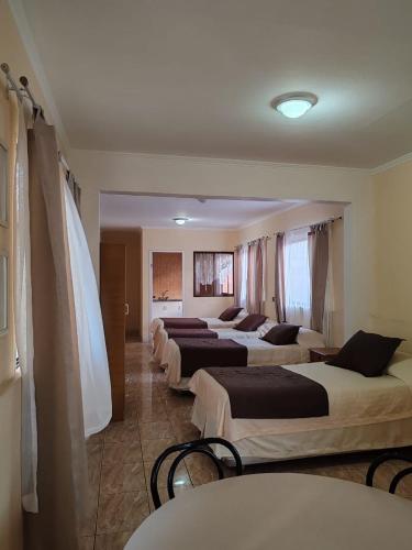 fila de camas en una habitación de hotel en Hotel Brasil, en Antofagasta