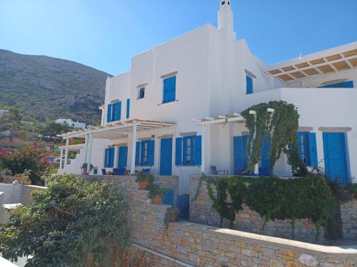 a white house with blue doors and stairs at Vicky's Studios in Órmos Aiyialís