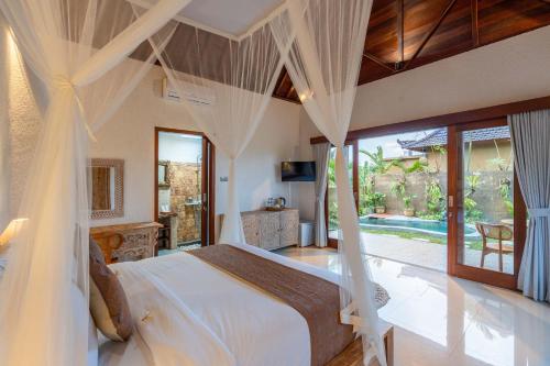 - une chambre avec un lit et des moustiquaires dans l'établissement Sawah Sebatu Villa, à Ubud