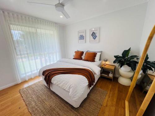 a bedroom with a bed with orange pillows on it at Cosy Beach House - Near Hot Springs. in Tootgarook