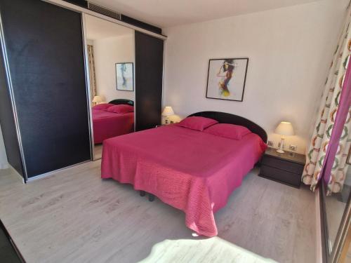 - une chambre avec un lit rose et un miroir dans l'établissement Appartement 3 pièces climatisé avec piscine et accès plage - FR-1-780-53, à Sainte-Maxime