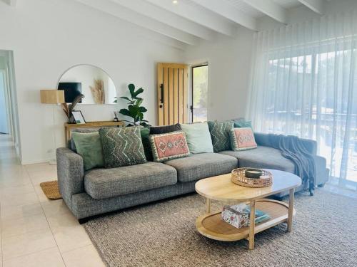 a living room with a couch and a table at Cosy Beach House - Near Hot Springs. in Tootgarook