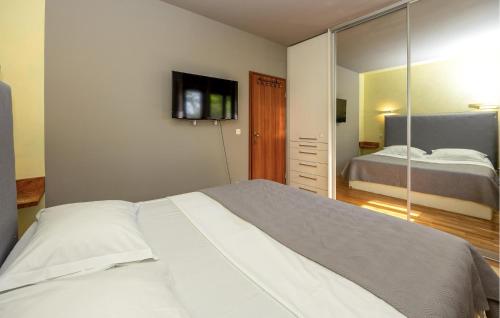 ein Schlafzimmer mit einem großen Bett und einem Spiegel in der Unterkunft 3 Bedroom Lovely Apartment In Solin in Solin