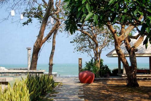 a red object sitting on a walkway next to trees at Baan Bayan - Hua Hin - SHA Extra Plus in Hua Hin