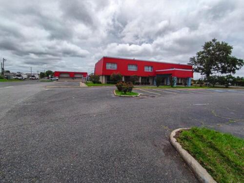 a red building with a parking lot in front of it at Clover Inn and Suites in Shreveport