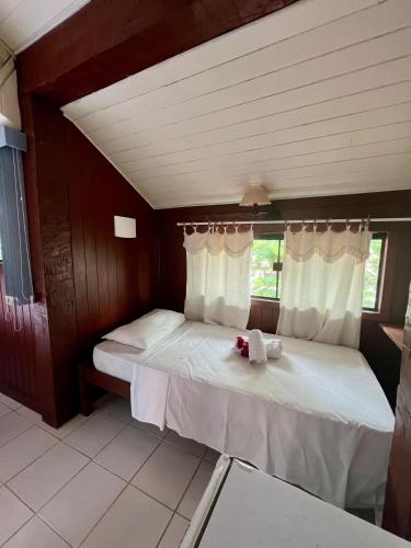 a bedroom with a large bed with white sheets at Pousada Alforria in Búzios