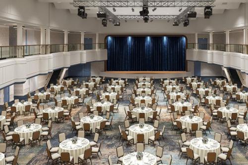 a large banquet hall with tables and a stage at Hotel Cleveland Autograph Collection in Cleveland