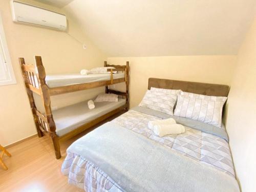 a bedroom with a bed and a bunk bed at Aconchego do Valle in Gramado