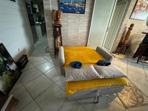 a room with a bed with a yellow blanket at residence caramboles in Fort-de-France